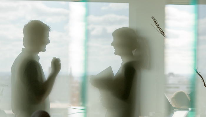 Silhouette of women and man talking