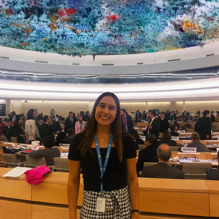 Monique is standing underneath a colourful ceiling at the United Nations in Geneva