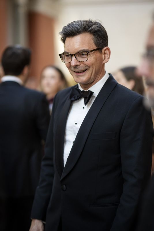 A close-up of Ambassador James Larsen, smiling, in formalwear at an event.