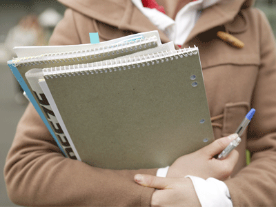 A person holding notebooks