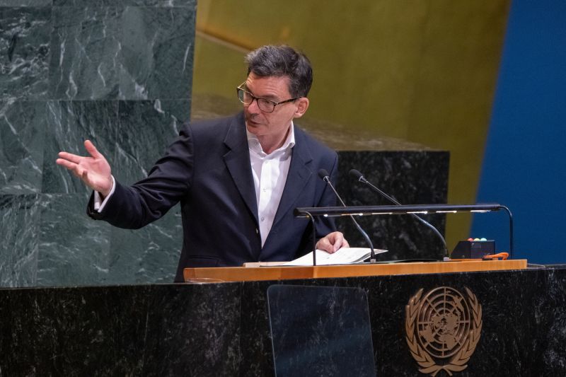 James Larsen gestures while speaking behind a podium in UN General Assembly.
