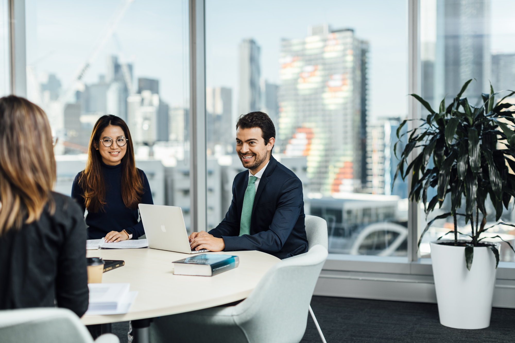 Professionals sitting at table with skyline in the background
