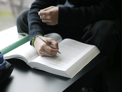 Person writing in a textbook