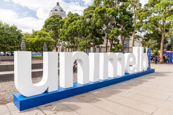 large unimelb sign on campus grounds