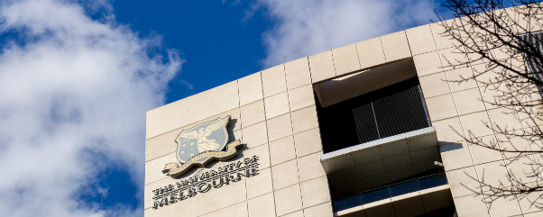 Close up of building with University of Melbourne logo, against blue sky
