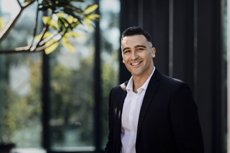 Image of Pablo Nogueira smiling in front of the Melbourne Law School building