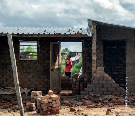 A woman surveys the damage to one of the estimated 2000 homes damaged when Cyclone Idai hit Tongogara Refugee Camp in Chipinge district in south-east Zimbabwe.